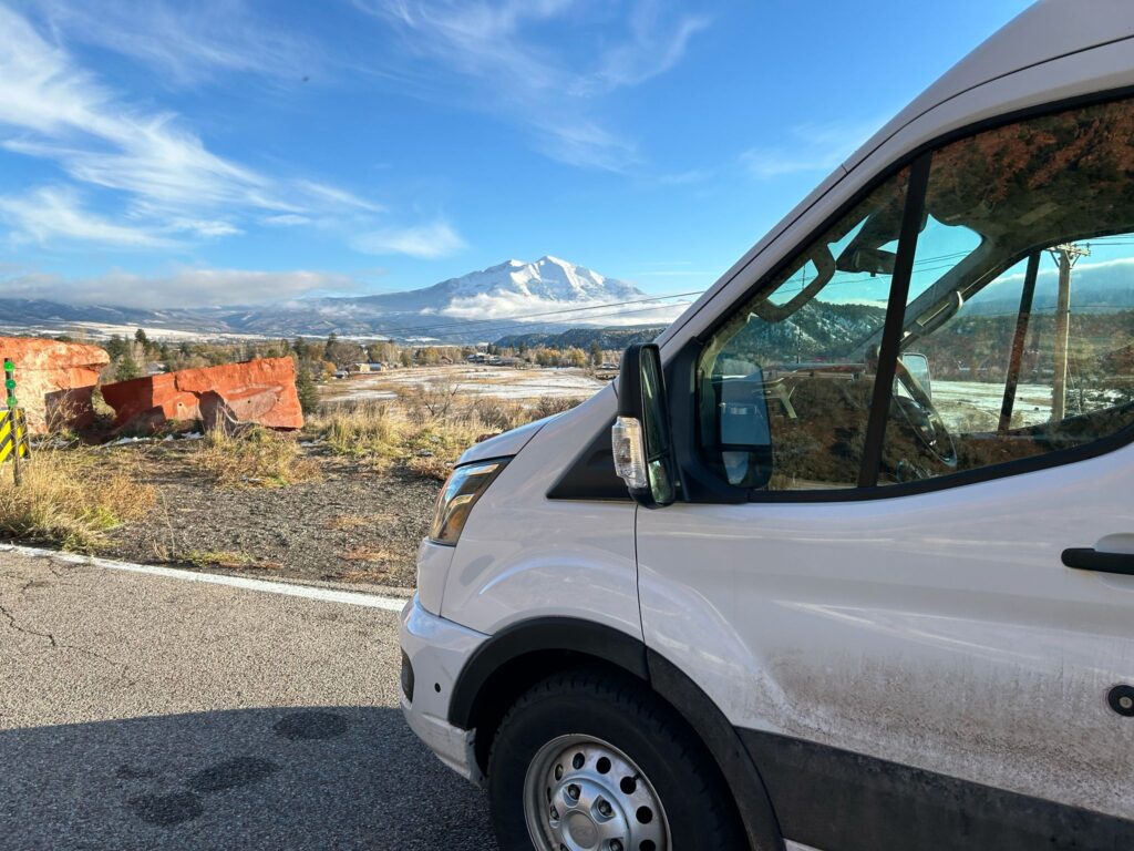 Early morning view of white vans outside snow-covered commercial and residential buildings.