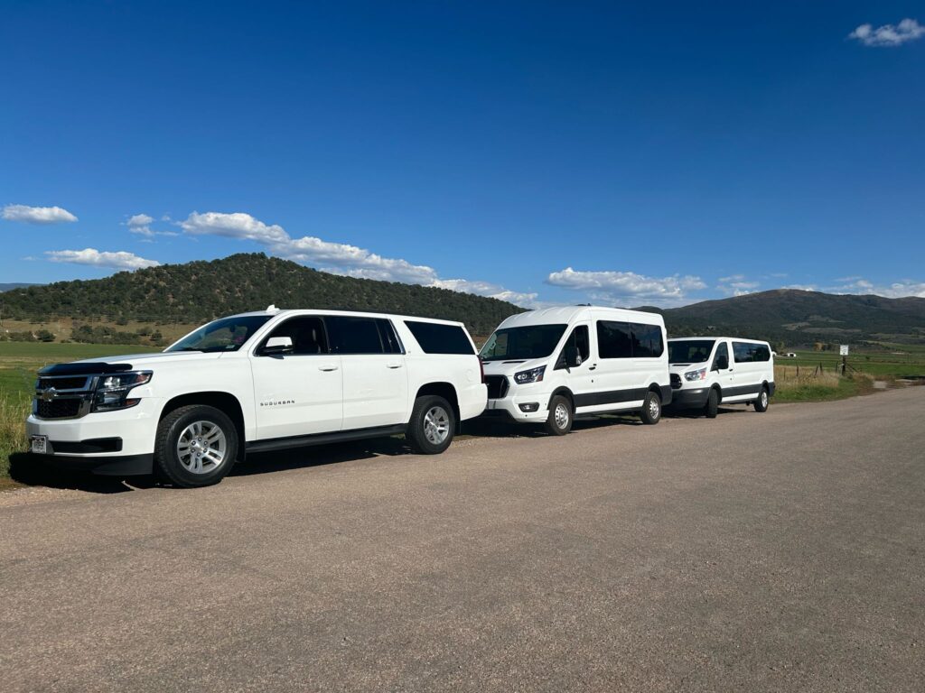 Triple van setup beside the road on a warm, sunny day.